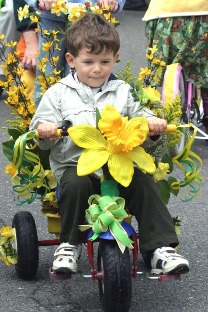 Child on bike decorated with daffodils